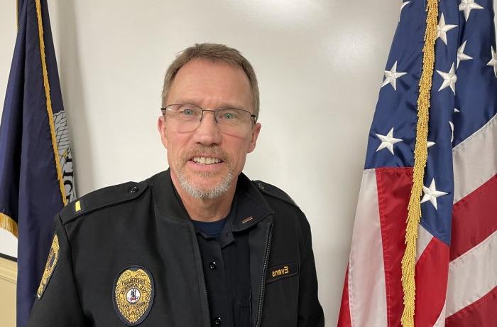 A man in a police uniform poses for a photo.